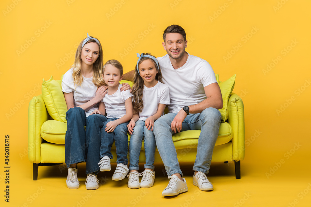 happy family sitting together on sofa on yellow happy family sitting together on sofa on yellow