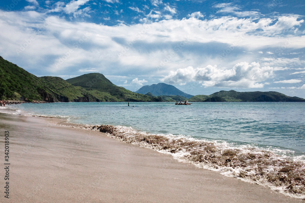 St.Kitts Island/Saint Kitts and Nevis - Nov 29, 2016: Black sand beach view with mountains at the background. Beautiful travel picture.