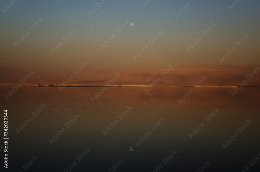 Dead sea, Israel, reflection of the sky in the sea in the evening brown beach, moon