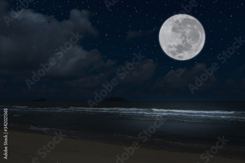 Full moon over sea in the dark night. © Onkamon