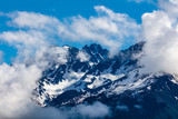 Snow capped rugged rocky mountains on blue sky day with clouds on the Kenai Peninsula of Alaska