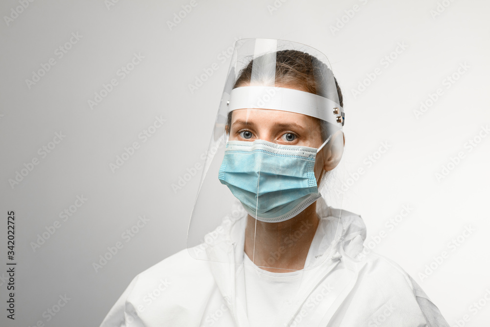 young woman in medical mask and protective shield on her head young woman in medical mask and protective shield on her head