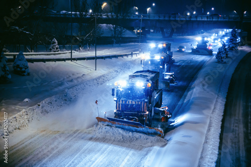 фотографія Working snow blowers shine on the road at night