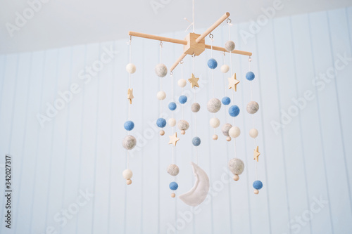 Baby crib mobile. Toys above the baby crib. Hanging soft balls for the child.