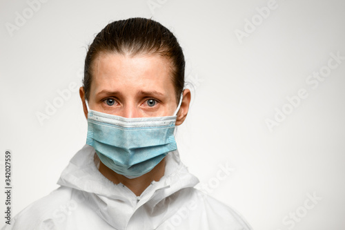 woman with blue eyes and sad expression in medical mask for protection against influenza.