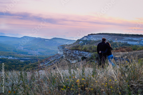 Fototapeta Naklejka Na Ścianę i Meble -  Couple in love. Two people watch sunset inthe mountains. Landscape background.