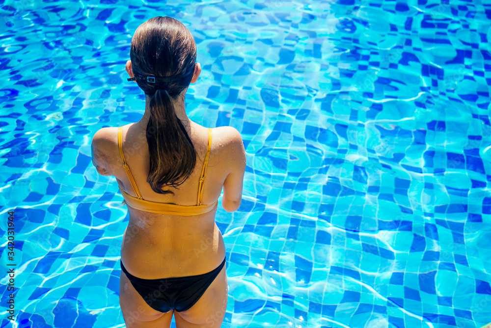 happy asian armless woman warming up before swimming at the tropical beach,she jumps