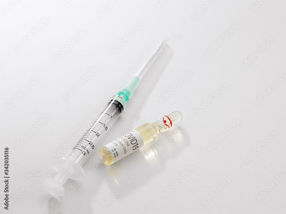 Close up view of the ampule with medicine and syringe on white back Close up view of the ampule with medicine and syringe on white back