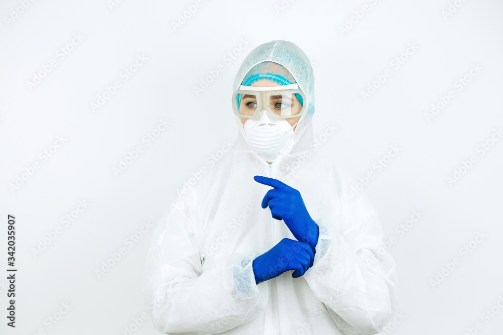 portrait of tired doctor after shift in the hospital. The doctor in protective clothing - glasses, mask, gloves on white background. The doctor treating patients with coronavirus. Covid-2019 portrait of tired doctor after shift in the hospital. The doctor in protective clothing - glasses, mask, gloves on white background. The doctor treating patients with coronavirus. Covid-2019