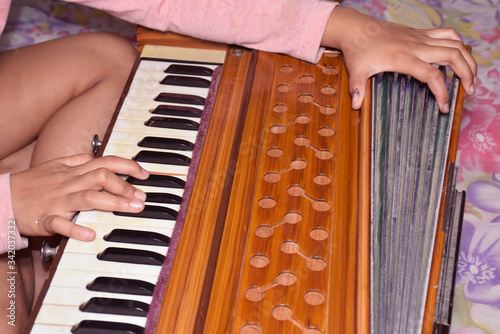 Close up shot of girl playing musical instrument HARMONIUM
