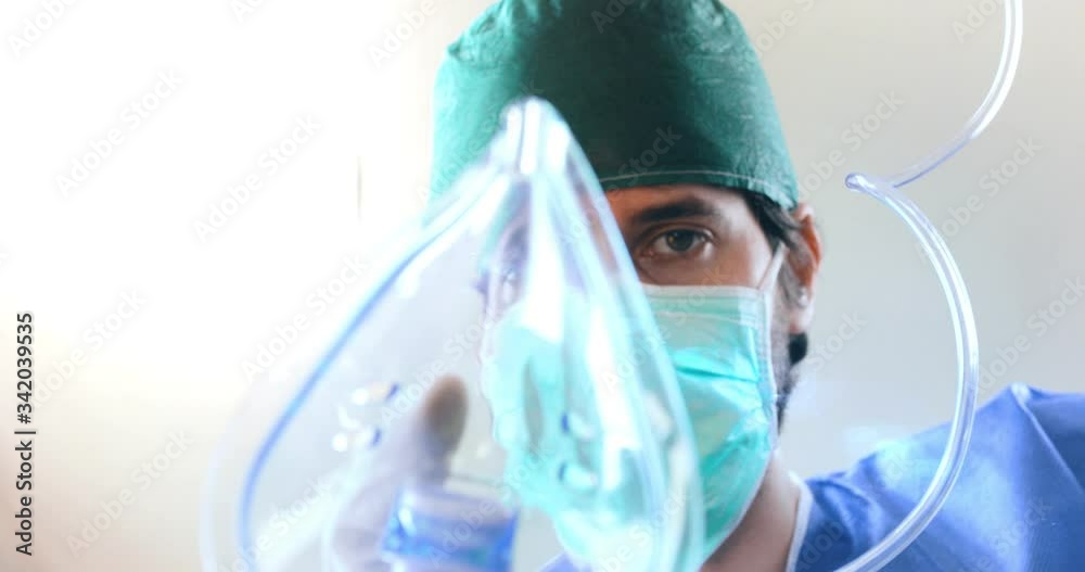 Punto di vista di un paziente mentre viene intubato con la mascherina di ossigeno da un dottore in sala operatoria durante il Coronavirus.