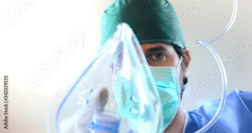 Punto di vista di un paziente mentre viene intubato con la mascherina di ossigeno da un dottore in sala operatoria durante il Coronavirus. photo