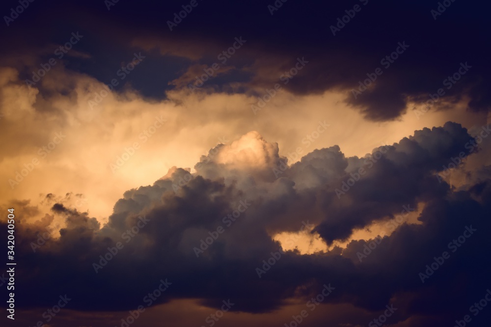Dark, dramatic nimbus clouds at sunset, lit by the last rays of sunlight before a storm. Dark, dramatic nimbus clouds at sunset, lit by the last rays of sunlight before a storm.