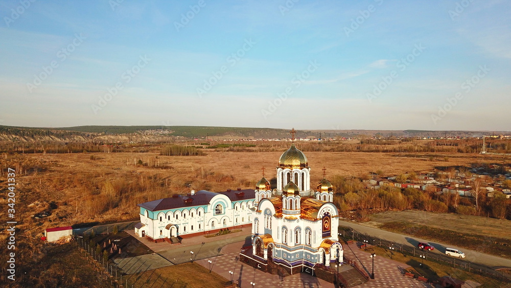 cathedral with golden domes and white walls, Kemerovo, shot from the drone.
