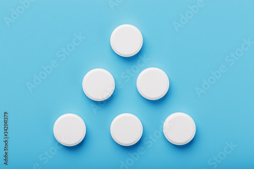 Round medicinal tablets in the shape of a triangle on a blue background, isolate.