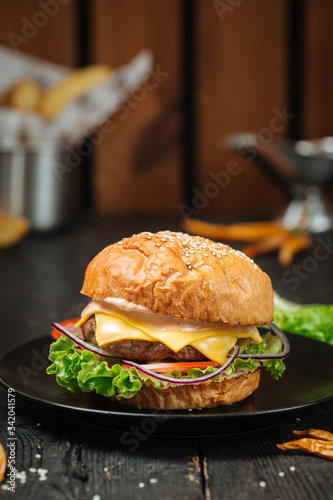 Tasty cheeseburger on a dark wooden background