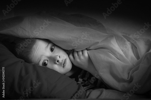 Foto black and white portrait boy in bed with his eyes open