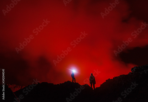 Two tourists with the headlights at the edge of Nyiragongo volcano