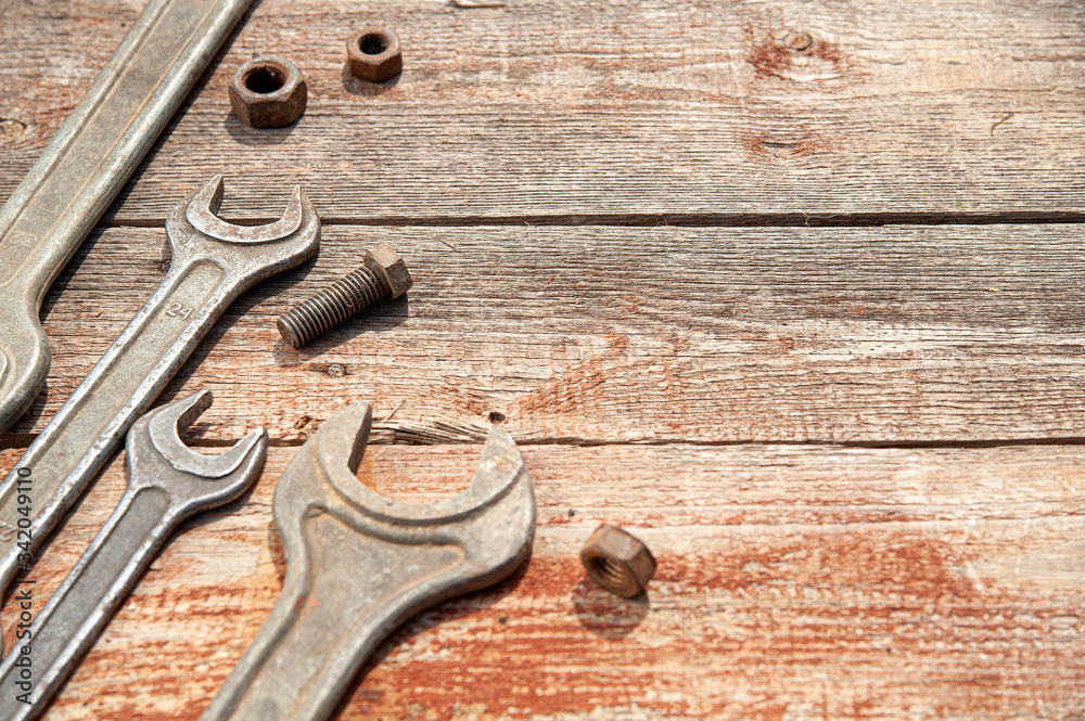 close-up of a set of hand wrenches, tools bolts, nuts lie on brown boards close-up of a set of hand wrenches, tools bolts, nuts lie on brown boards