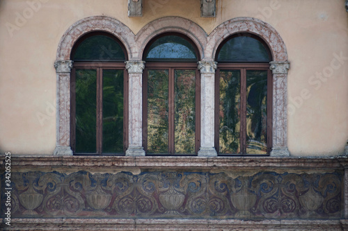 Italian windows on the beige wall facade with the pattern under them