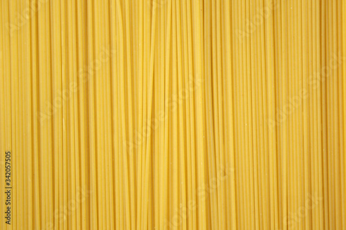Yellow long spaghetti . Thin pasta arranged in rows. Yellow italian pasta. Long spaghetti. Raw spaghetti wallpaper. Thin spaghetti. Food background concept.