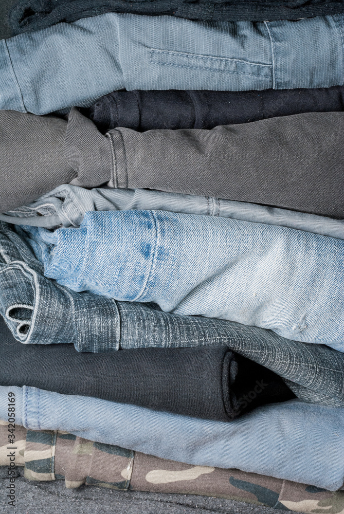 stack of folded jeans in a closet