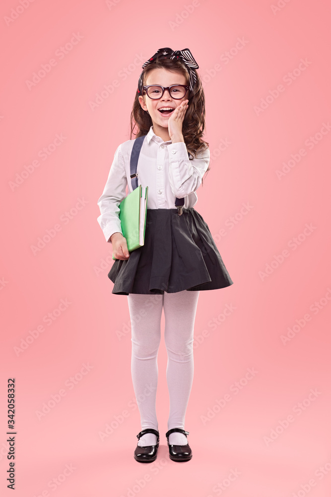 Surprised little school girl on pink background Surprised little school girl on pink background