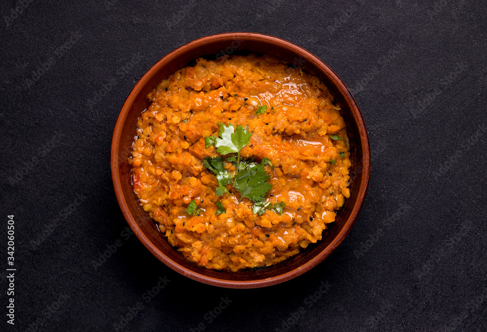 Dhal Indian soup of red lentils and spices on a black background. Traditional cuisine Dhal Indian soup of red lentils and spices on a black background. Traditional cuisine