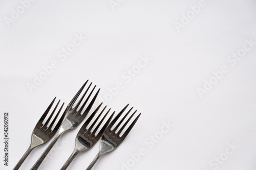 A close up of a Forks lie on a white background