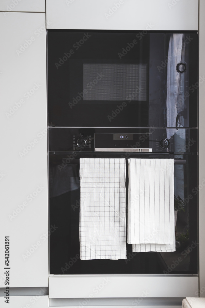 Modern built-in microwave and oven in the kitchen close-up Modern built-in microwave and oven in the kitchen close-up