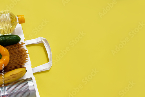 Food donations on a yellow uniform background. Top view with copy space.