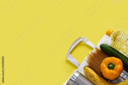 Food donations on a yellow uniform background. Top view with copy space.