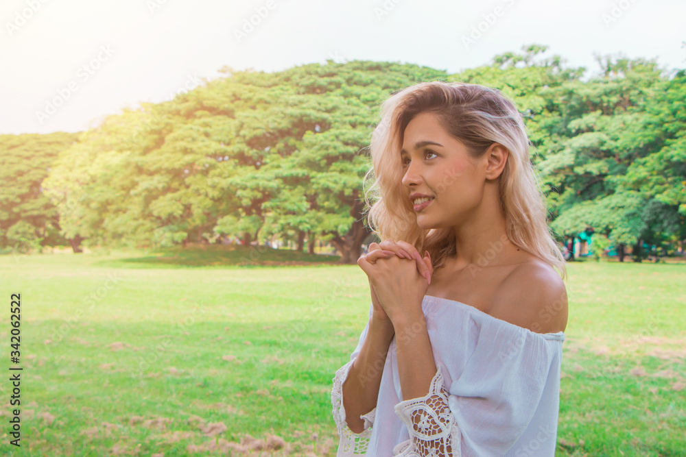 Woman pray in the garden, Beautiful woman with white dress believe in God, christian study concept. Woman pray in the garden, Beautiful woman with white dress believe in God, christian study concept.