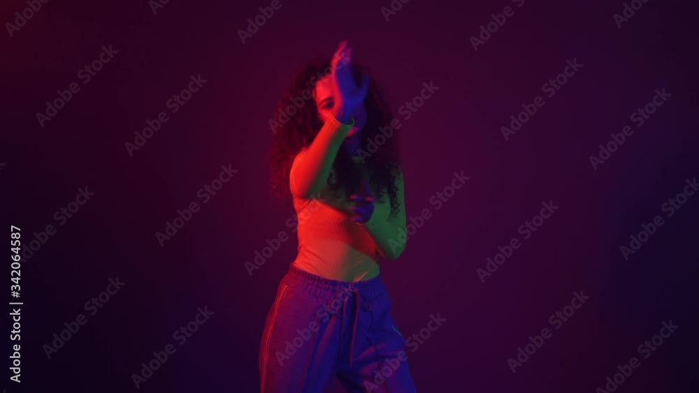 African-American woman dancing against dark background African-American woman dancing against dark background