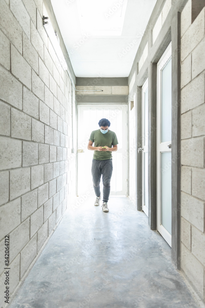 Young man with a face mask working walked when entering a hospital Young man with a face mask working walked when entering a hospital