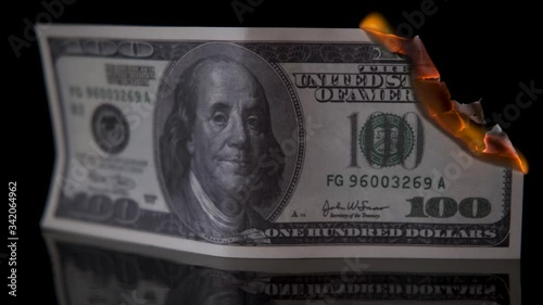 Us dollar bill money is on fire on black background,accelerated large frame, concept of global financial crisis and inflation.