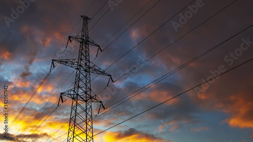 Silhouette of steel lattice tower on dramatic sky background. Transmission tower, used to support an overhead power line