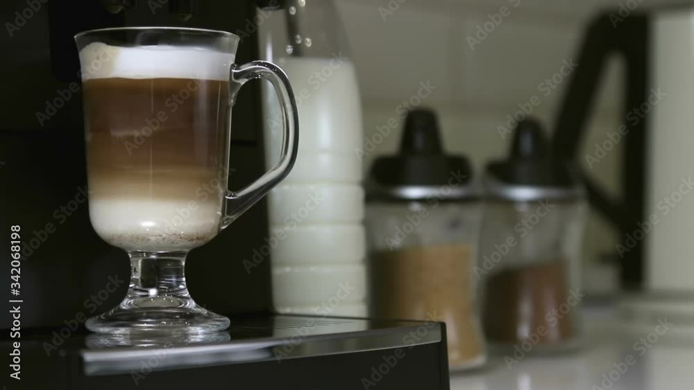 hot cappuccino from the coffee machine is poured into a glass Cup hot cappuccino from the coffee machine is poured into a glass Cup