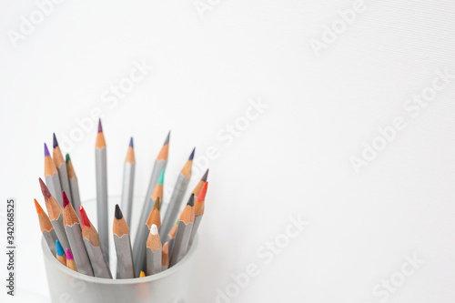 A colorful pencils in a glass in the white background. Drawing by pencils. 