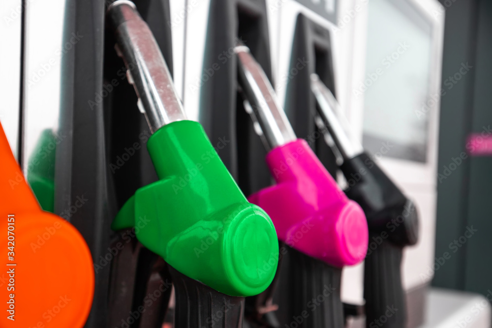 bright clean pistols at a gas station with fuel for a car. Detail of a gasoline pump in a gas station. bright clean pistols at a gas station with fuel for a car. Detail of a gasoline pump in a gas station.