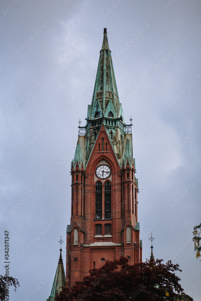 The chapel building is made of red brick with a green dome