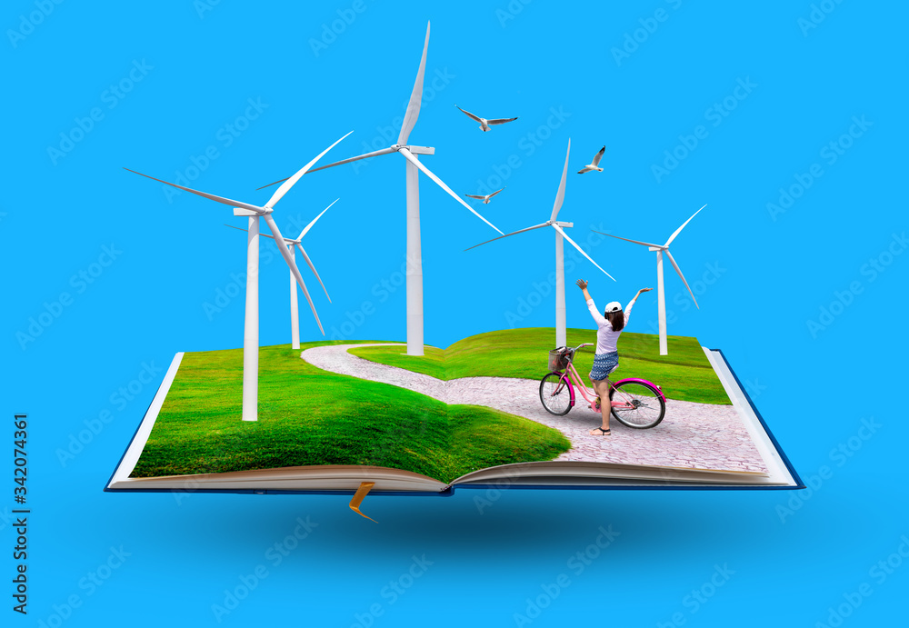 Open book with Young happy girl riding bicycle on meadow in a wind turbine, The eco power concept.