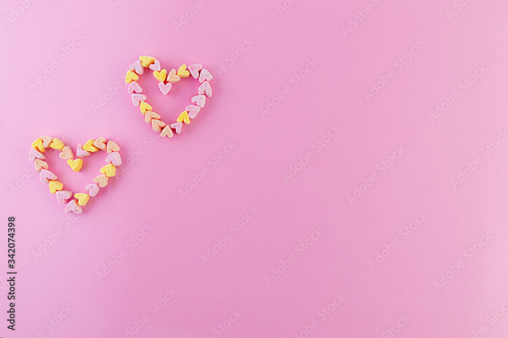 Two little multi-colored hearts on a pink background. Background Valentine's Day, marriage, love, mother's day.