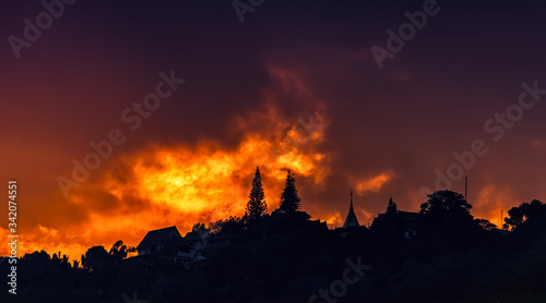 Beautiful sunset and orange sky, red clouds outdoor with the silhouetted Was Phra That Doi Suthep Temple, Important landmarks of Chiang Mai in Thailand.