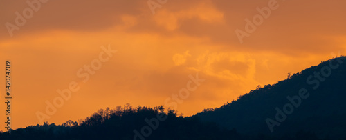 Panorama Sunset landscape view and orange sky with silhouette mountains.
