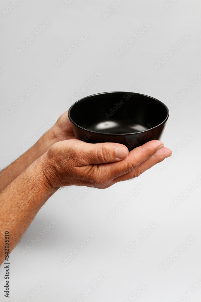 Man holds an empty bowl in his hands. Man holds an empty bowl in his hands.