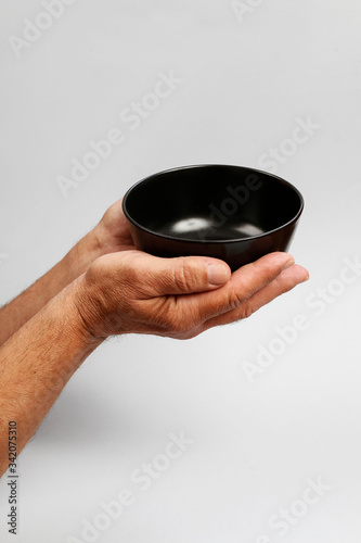 Man holds an empty bowl in his hands.