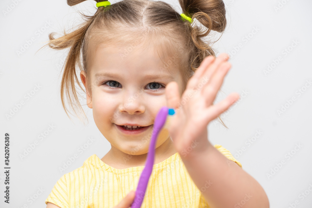 little girl smiles and holds forward a toothbrush little girl smiles and holds forward a toothbrush