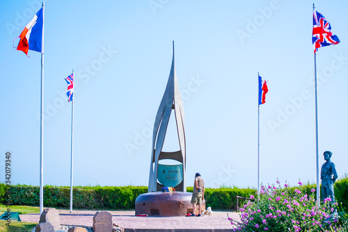 Fotografie, Tablou June 6th landings memorial to british soldiers with person and dog standing nearby