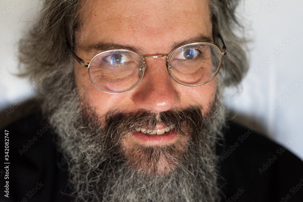 Close-up portrait of a happy smiling middle-aged man with a beard and glasses Close-up portrait of a happy smiling middle-aged man with a beard and glasses